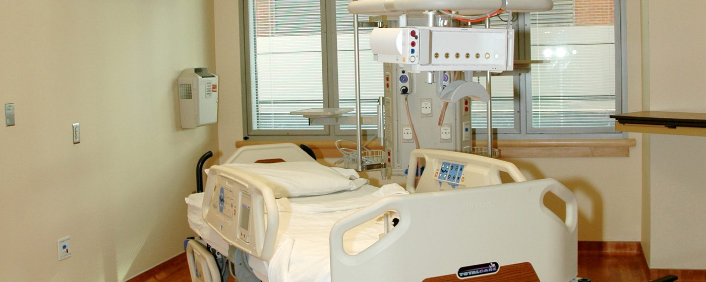 An empty patient room with a hospital bed