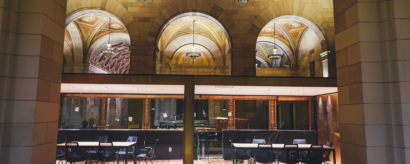 A glass-walled meeting room visible from an adjoining lounge area