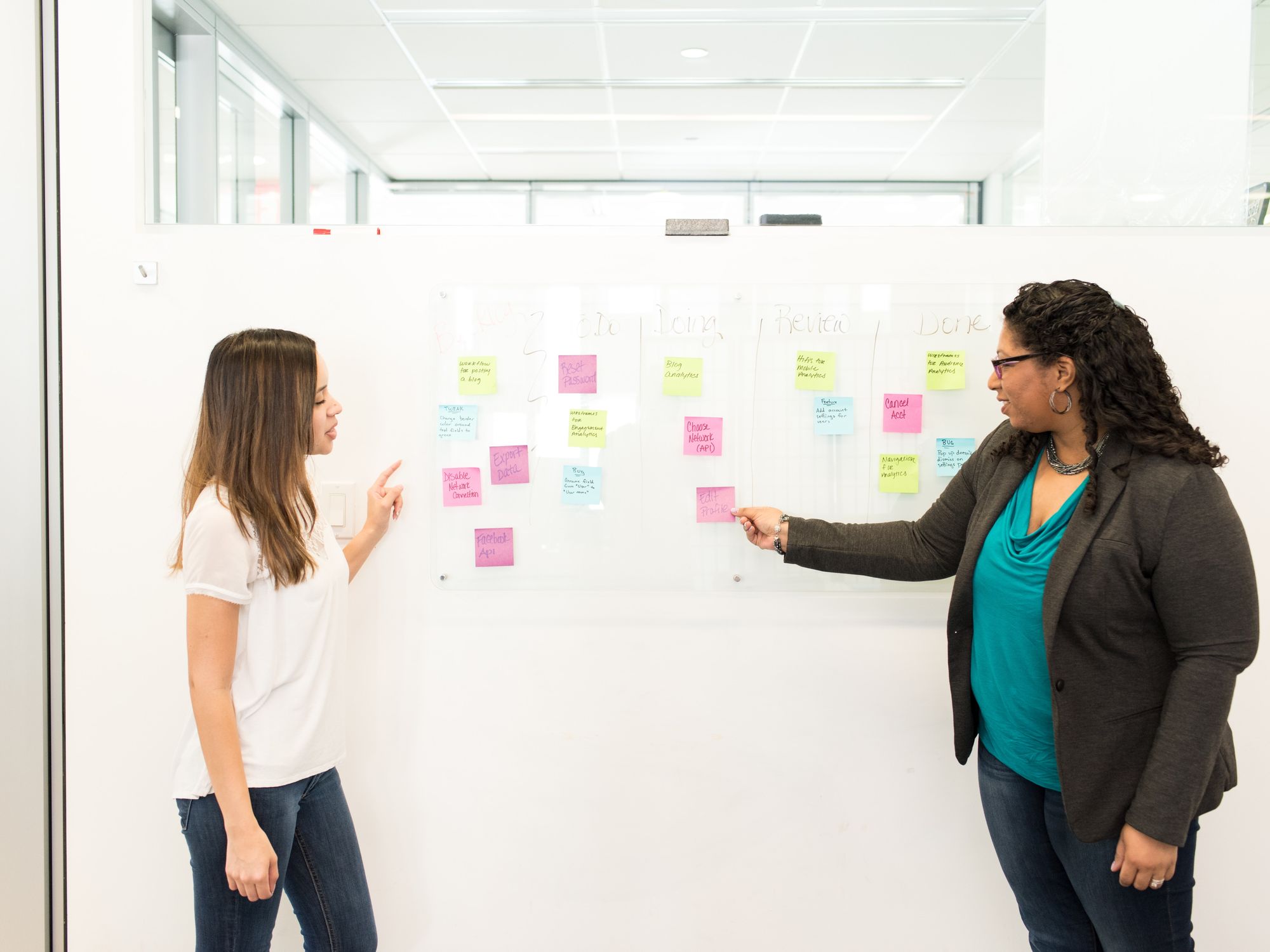 Two colleagues at a wall of sticky notes