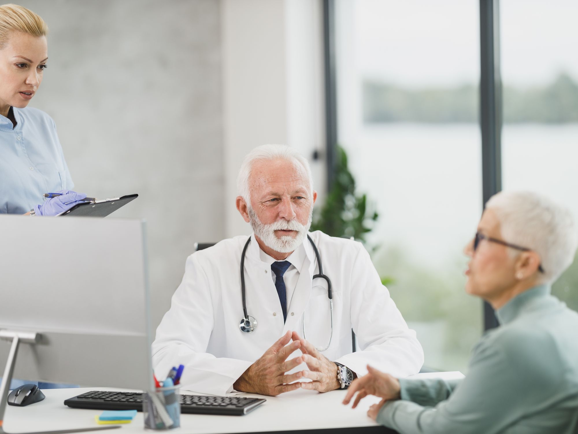 A doctor talking with an older patient at a desk