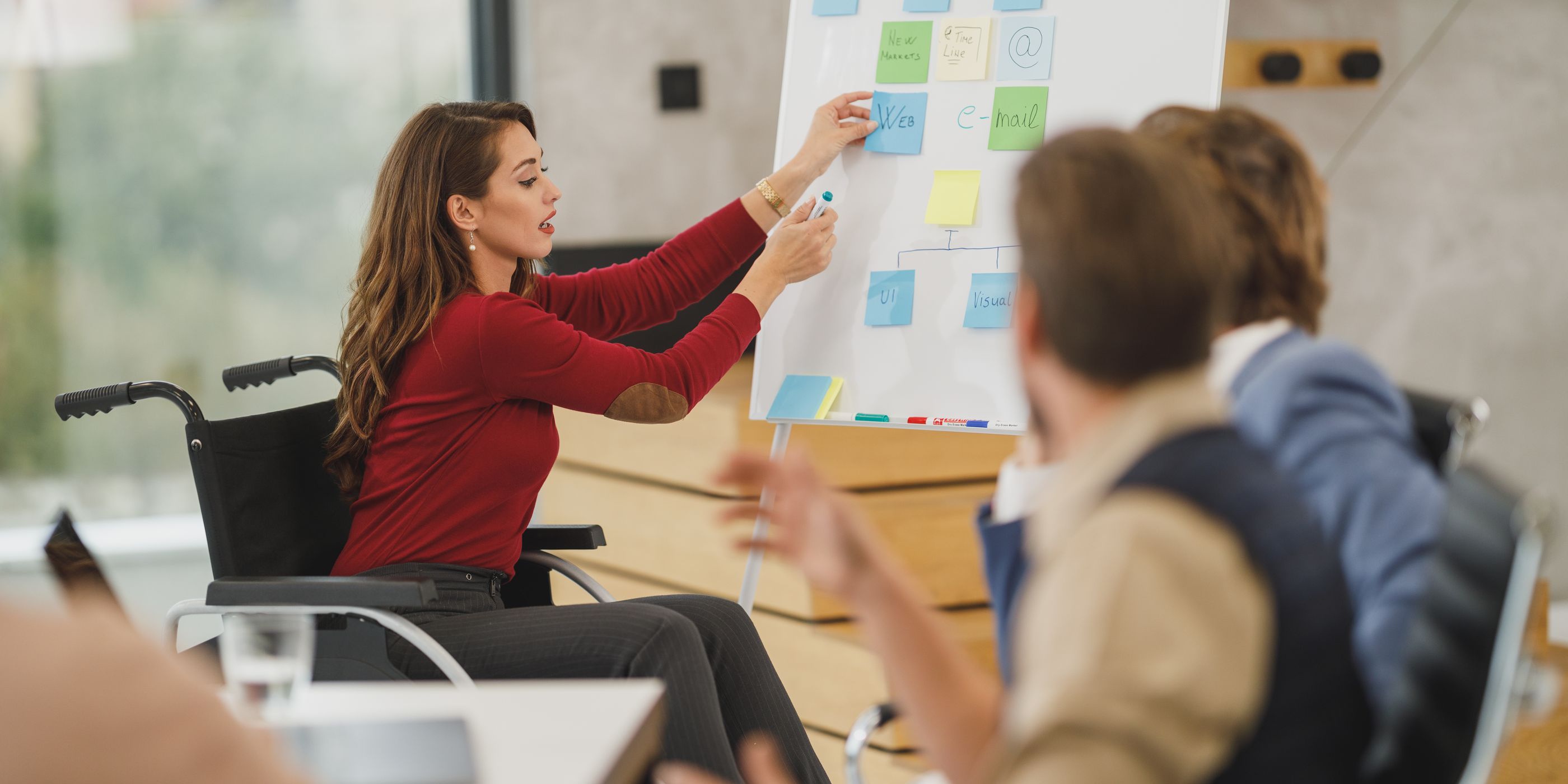 A woman in a wheelchair presenting at a flipchart