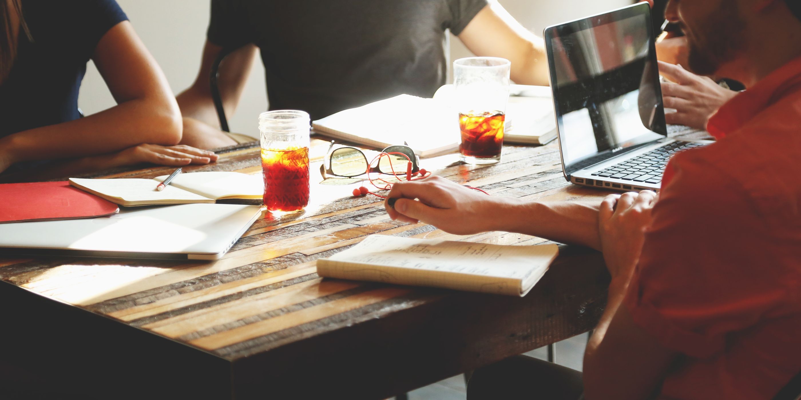 Colleagues working through papers at a wooden table