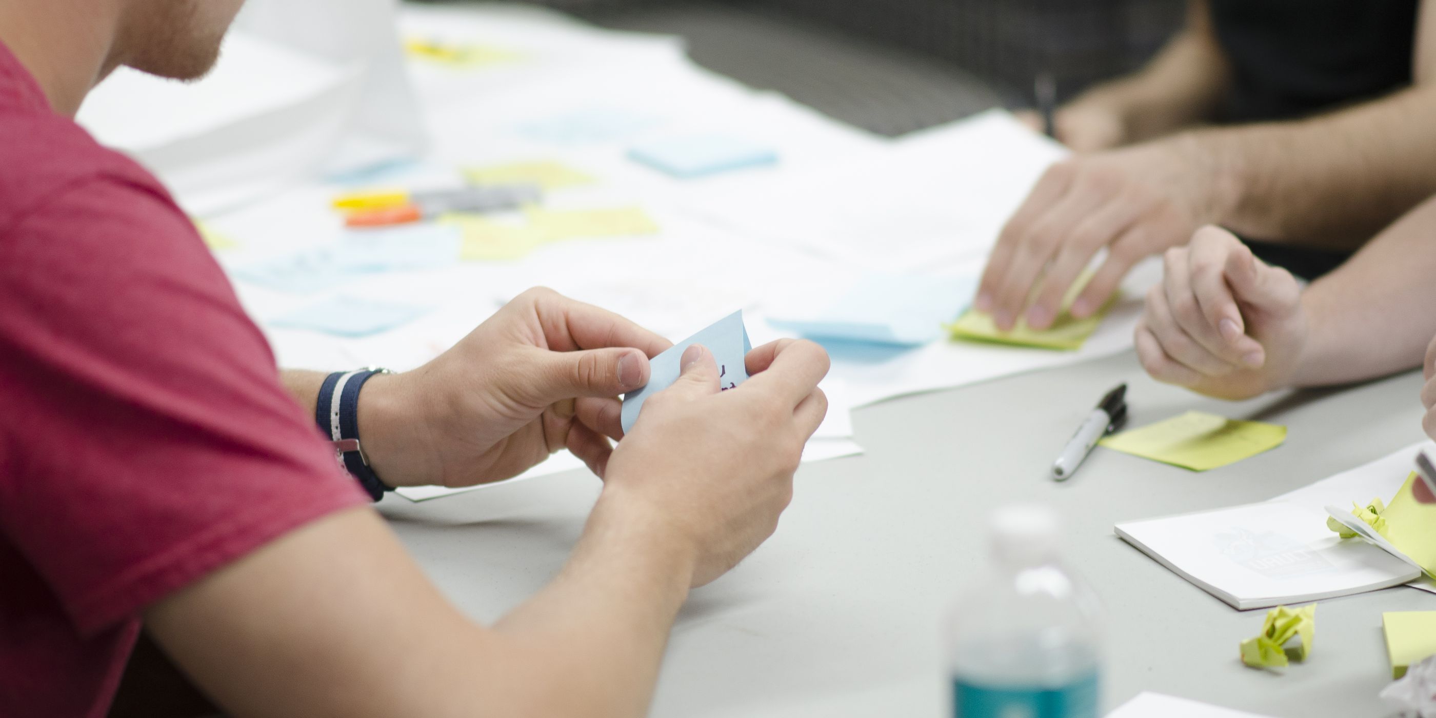 Colleagues sorting sticky notes on a table