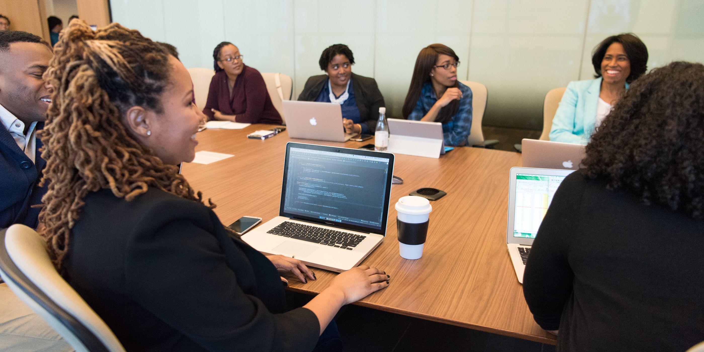 A team around a meeting-room table with laptops