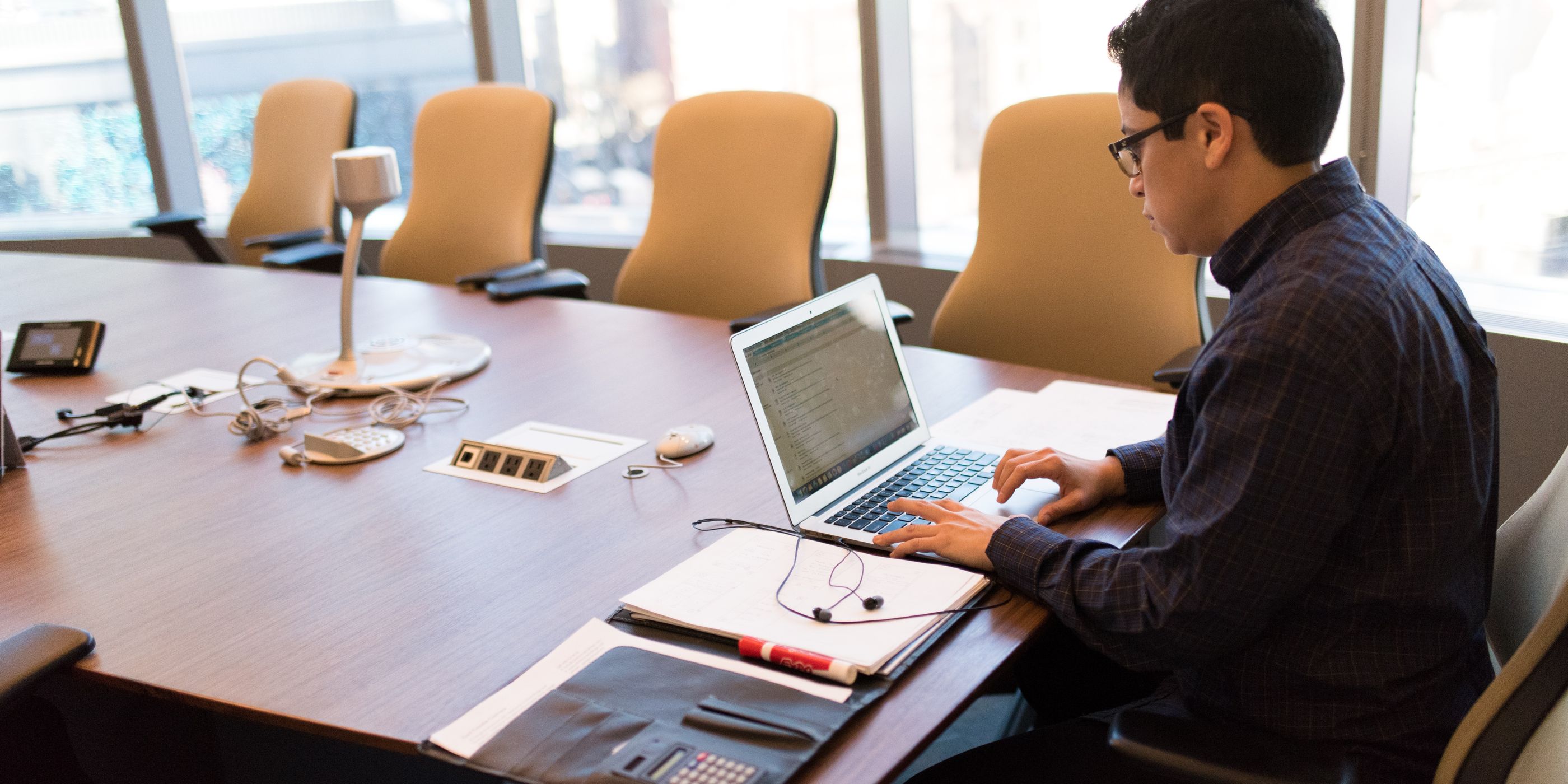 A man working on a laptop in a meeting room