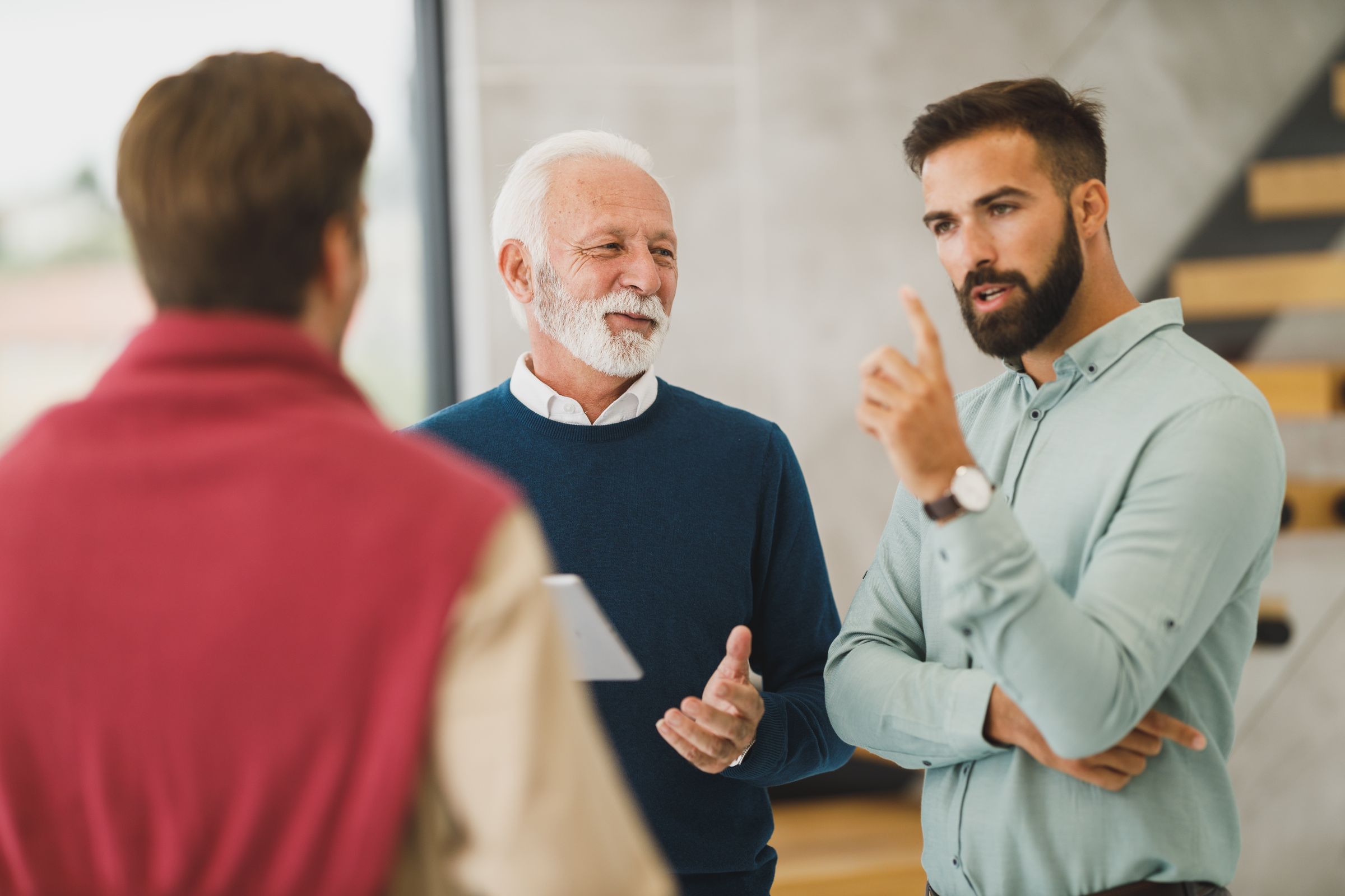 Three men in conversation in an office