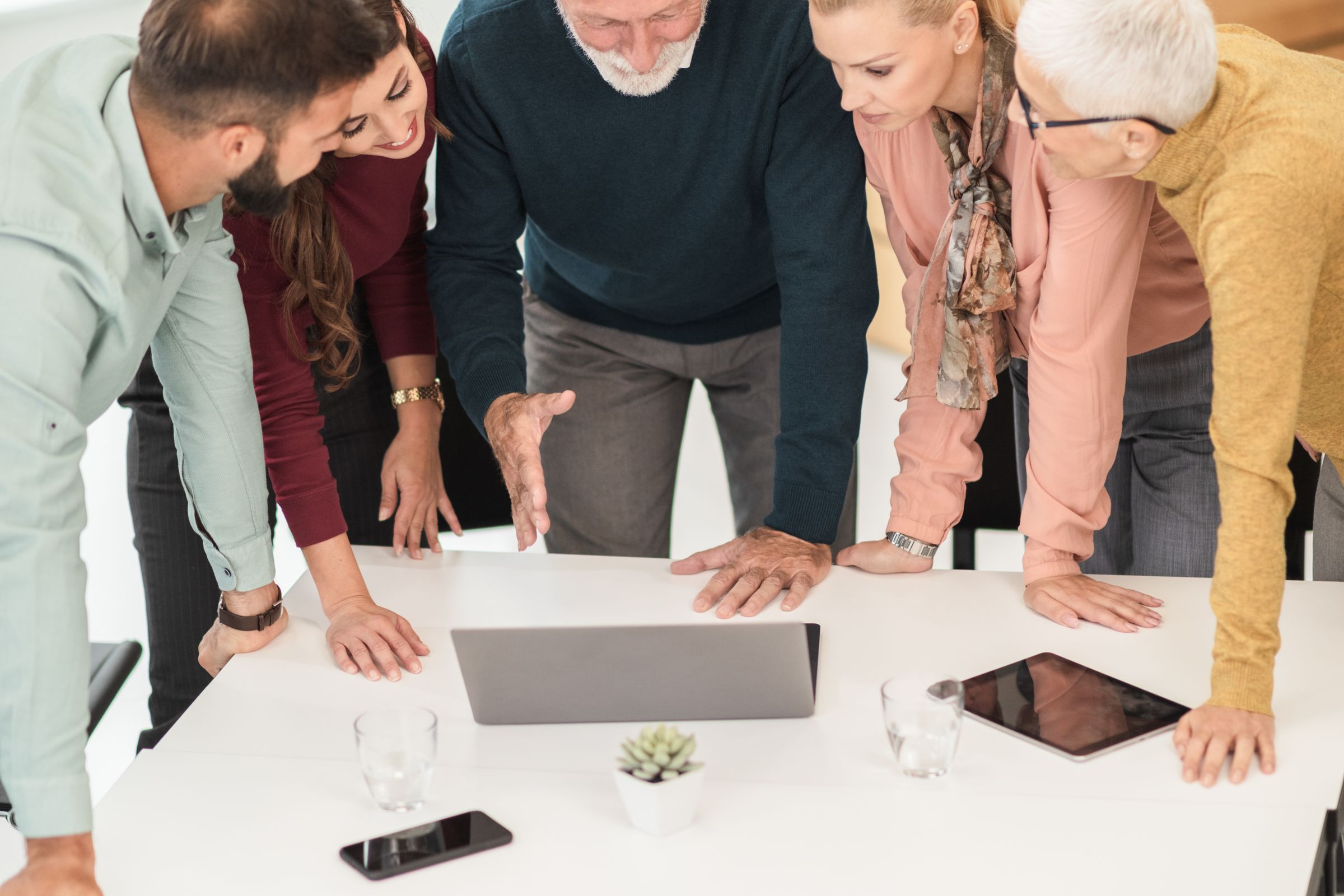 A group leaning over a plan on a table