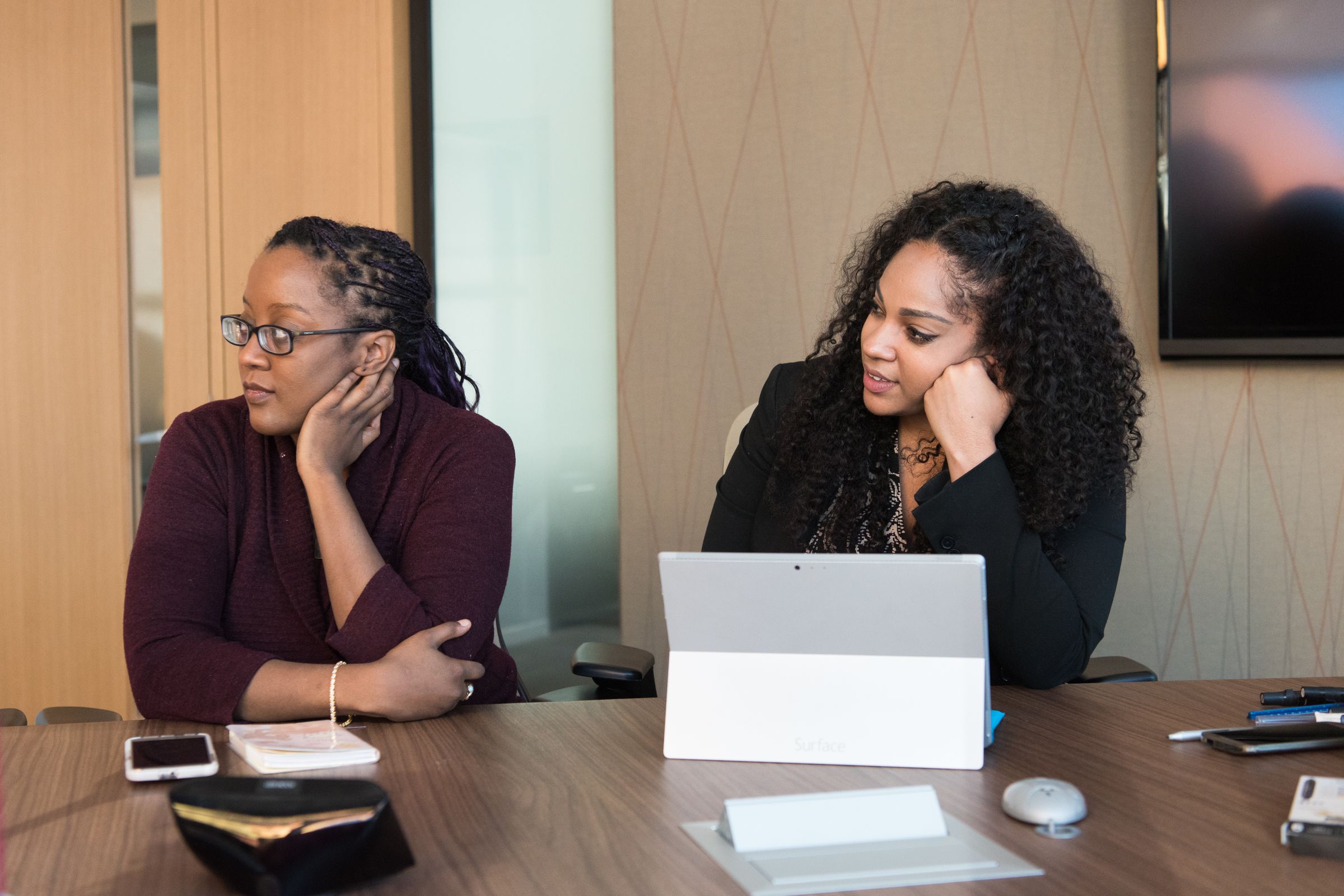 Two colleagues laughing over a laptop