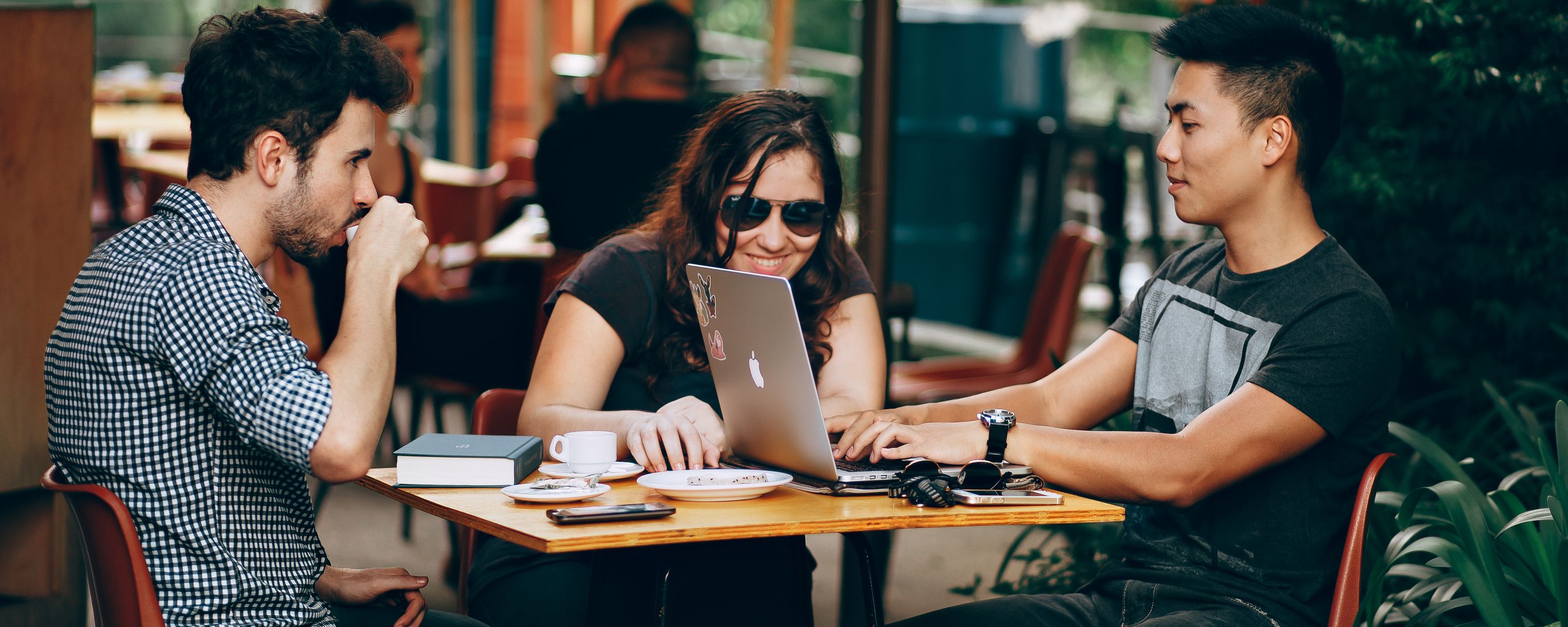 Colleagues in a cafe meeting over laptops