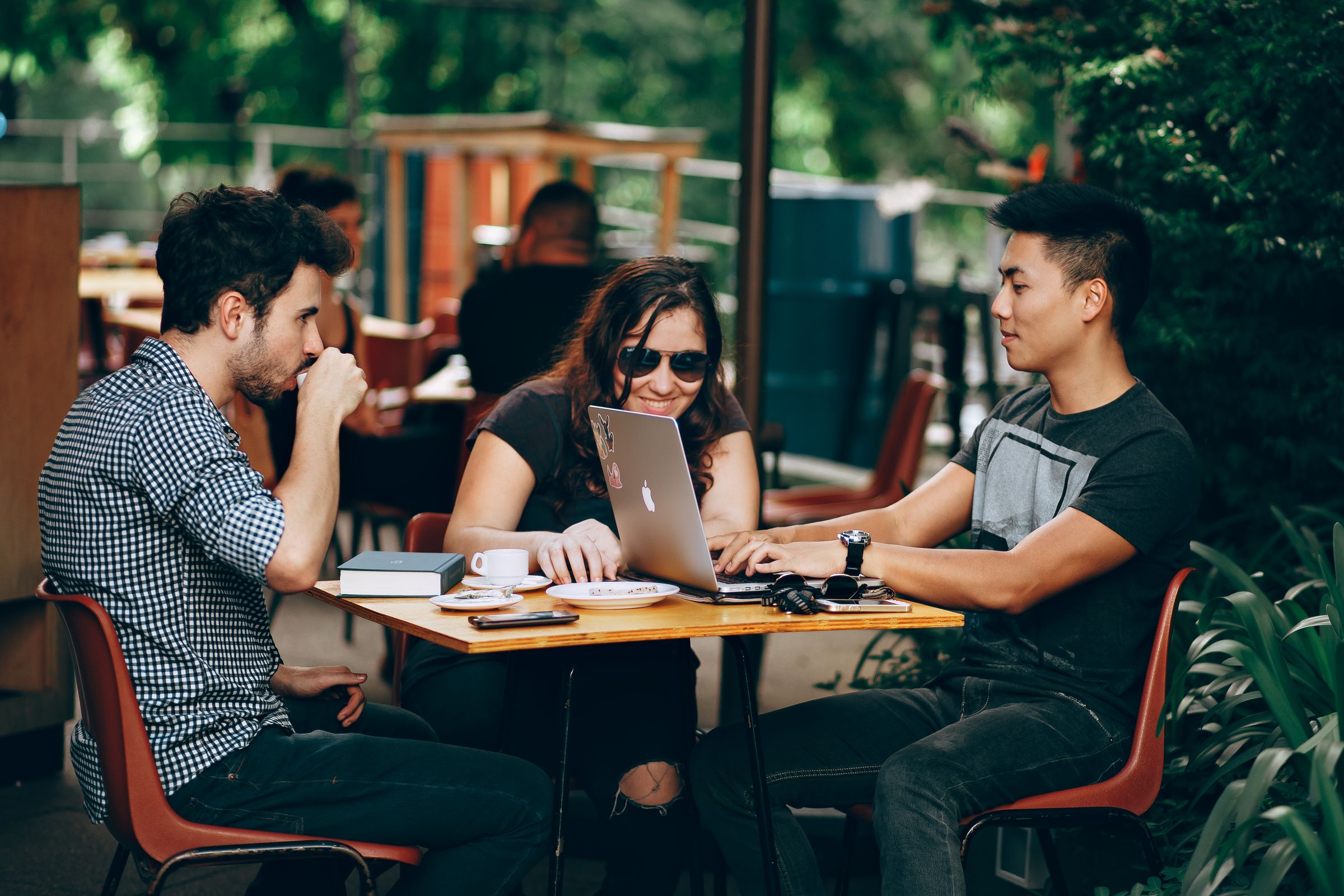 Colleagues in a cafe meeting over laptops