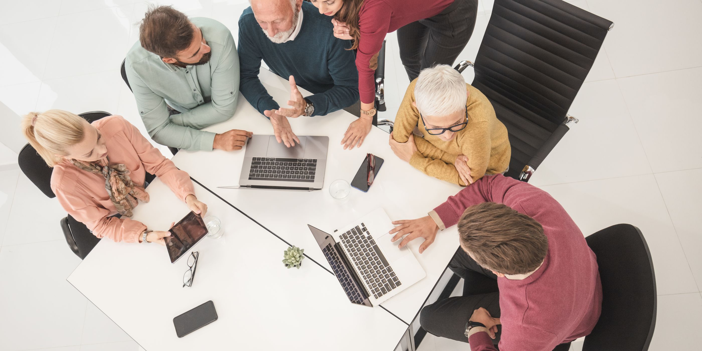 A team around a table with laptops, seen from above
